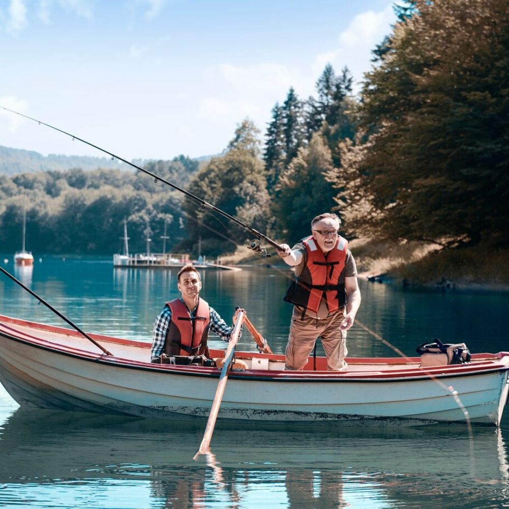 Two people in a boat on a calm lake with trees in the background